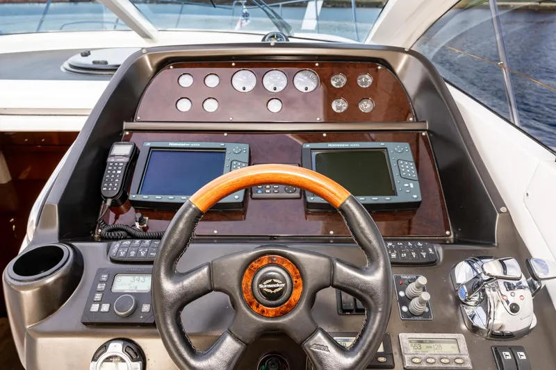 Slide: The Image of 2007 Sunseeker Portofino 47 yacht helm with navigation instruments and wooden steering wheel. - 16