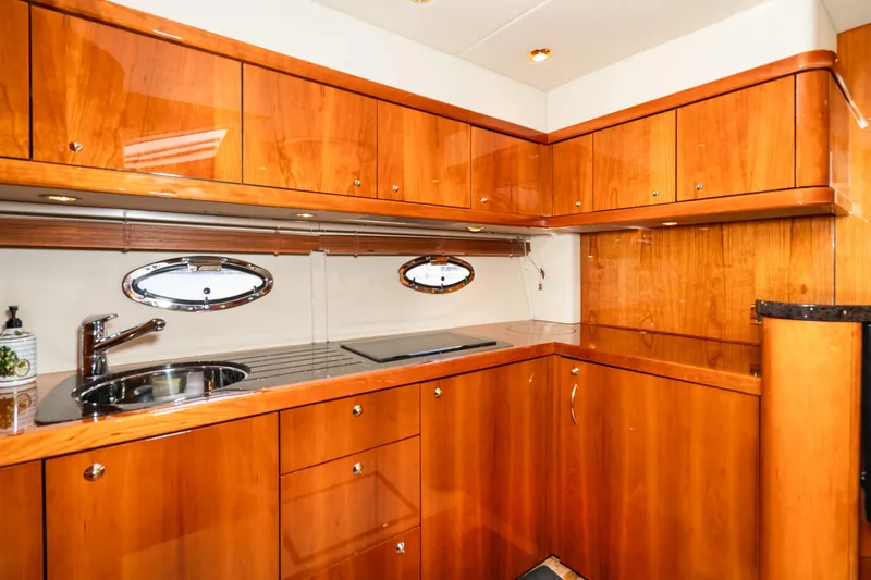Slide: The Image of 2007 Sunseeker Portofino 47 yacht kitchen with wooden cabinets and stainless steel sink. - 35