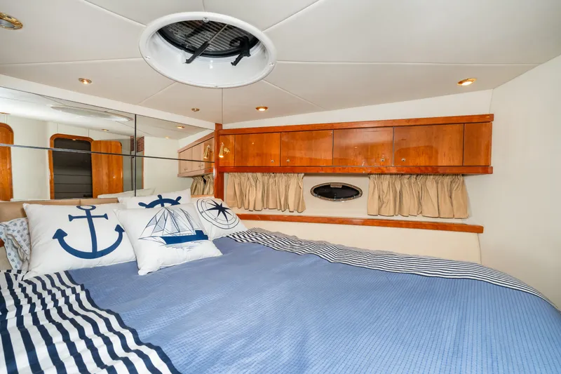 Slide: The Image of Sunseeker Portofino 47 2007 yacht bedroom with nautical-themed bedding and wooden cabinets. - 43