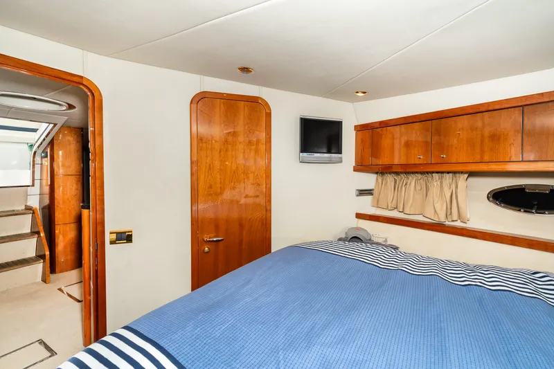Slide: The Image of 2007 Sunseeker Portofino 47 yacht bedroom with wooden cabinetry and blue bedding. - 44