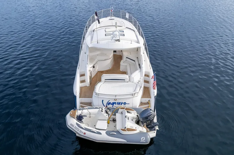 Slide: The Image of 2007 Sunseeker Portofino 47 yacht on calm water, rear view with tender boat. - 9