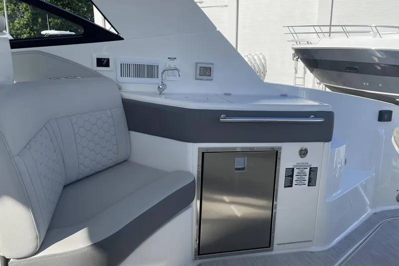 Slide: The Image of 2024 Sea Ray Sundancer 320 Outboard interior with seating and kitchenette area. - 13