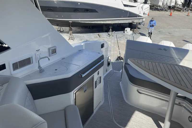 Slide: The Image of 2024 Sea Ray Sundancer 320 Outboard interior with kitchenette and seating area. - 14