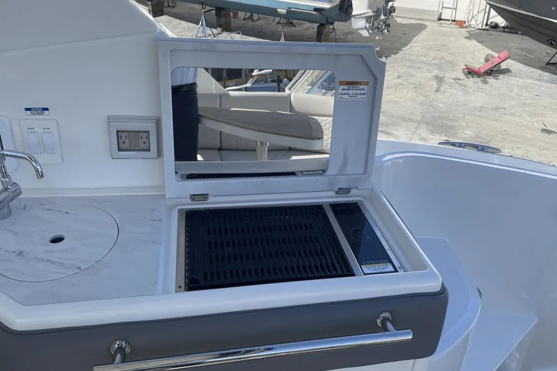 Slide: The Image of 2024 Sea Ray Sundancer 320 Outboard boat kitchen with grill and sink. - 16