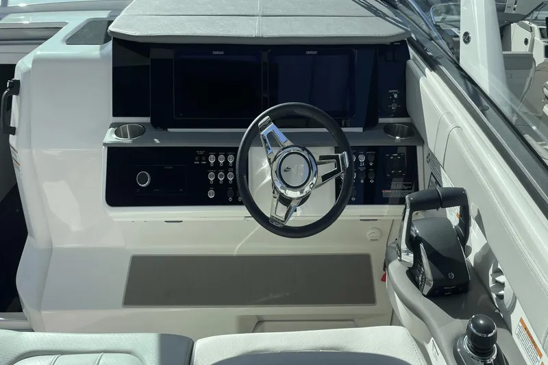 Slide: The Image of 2024 Sea Ray Sundancer 320 Outboard helm with modern controls and steering wheel. - 18
