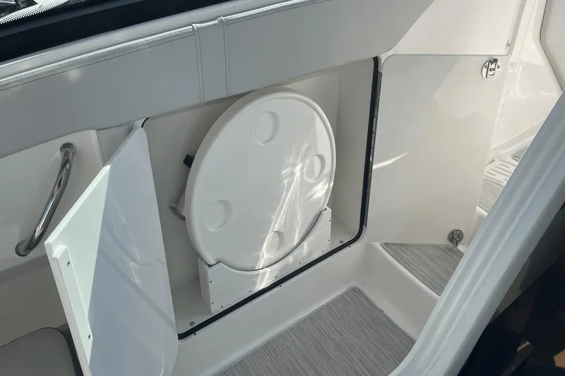 Slide: The Image of 2024 Sea Ray Sundancer 320 Outboard interior storage compartment with open door. - 21