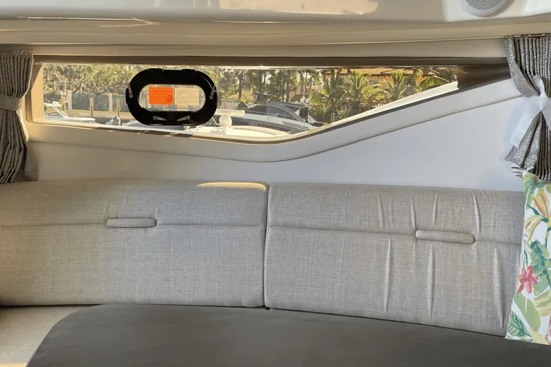 Slide: The Image of Interior of 2024 Sea Ray Sundancer 320 Outboard with gray seating and window view. - 31
