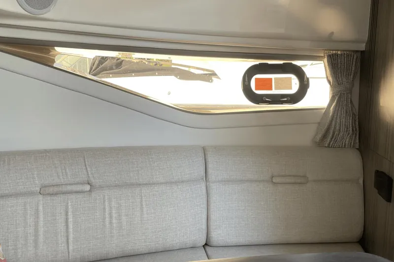 Slide: The Image of Interior of 2024 Sea Ray Sundancer 320 Outboard with window and gray seating. - 32