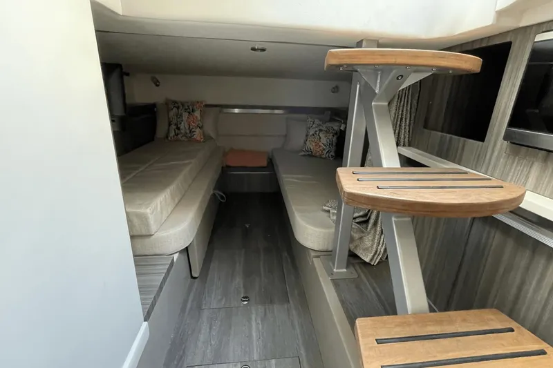Slide: The Image of 2024 Sea Ray Sundancer 320 Outboard cabin interior with twin beds and wooden steps. - 34