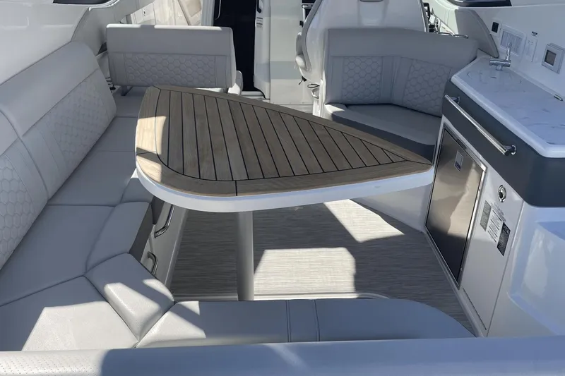 Slide: The Image of 2024 Sea Ray Sundancer 320 Outboard interior with elegant seating and wooden table. - 6