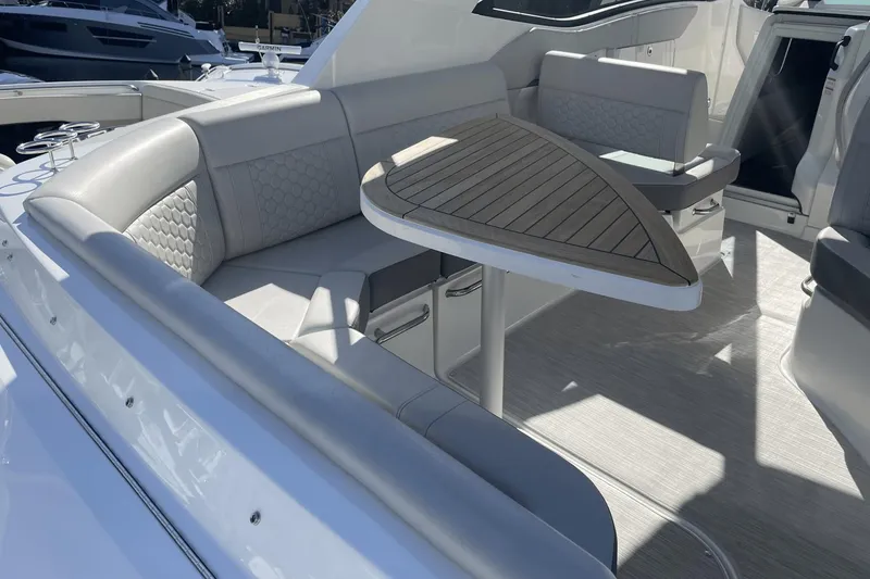 Slide: The Image of 2024 Sea Ray Sundancer 320 Outboard interior with elegant seating and wooden table. - 7