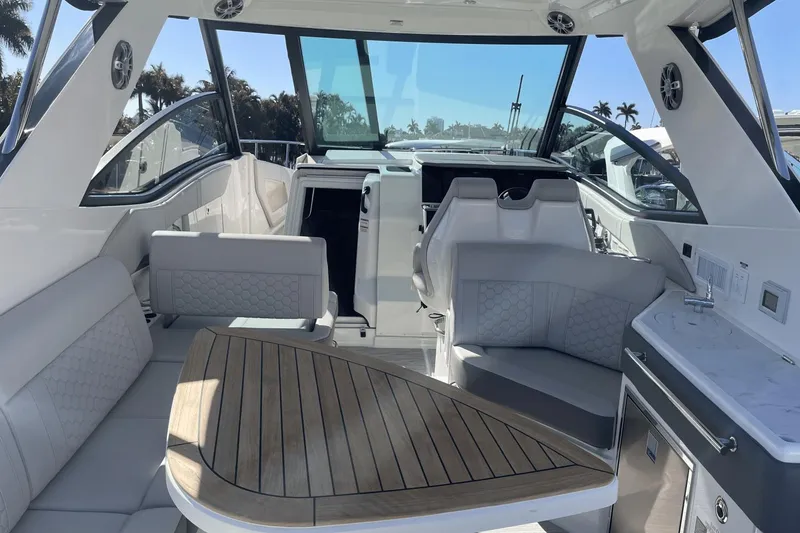 Slide: The Image of 2024 Sea Ray Sundancer 320 Outboard interior with seating, table, and helm. - 8