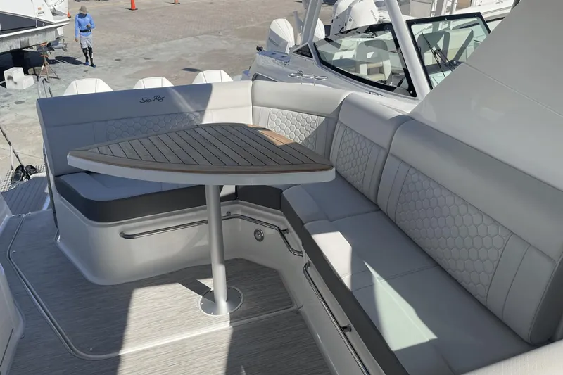 Slide: The Image of 2024 Sea Ray Sundancer 320 Outboard interior with elegant seating and wooden table. - 9