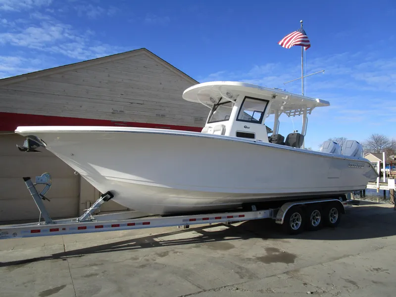 The Image of 2024 Sea Pro 322 Offshore boat on a trailer with an American flag in the background. - 1