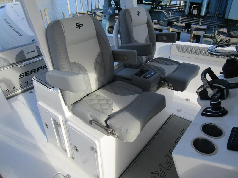 Slide: The Image of 2024 Sea Pro 322 Offshore boat interior with dual captain's chairs and control panel. - 19