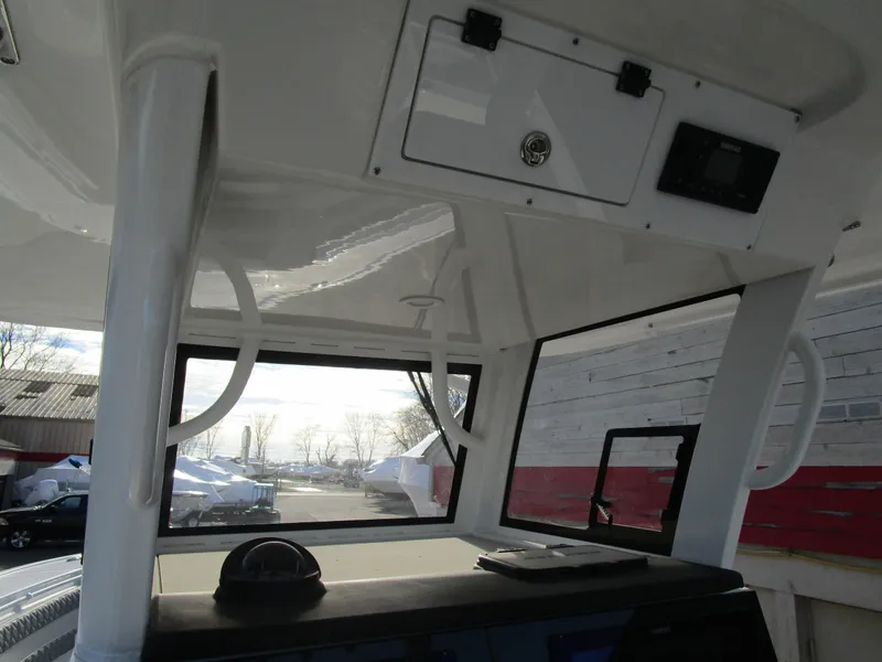 Slide: The Image of 2024 Sea Pro 322 Offshore boat interior with helm station and overhead storage. - 25