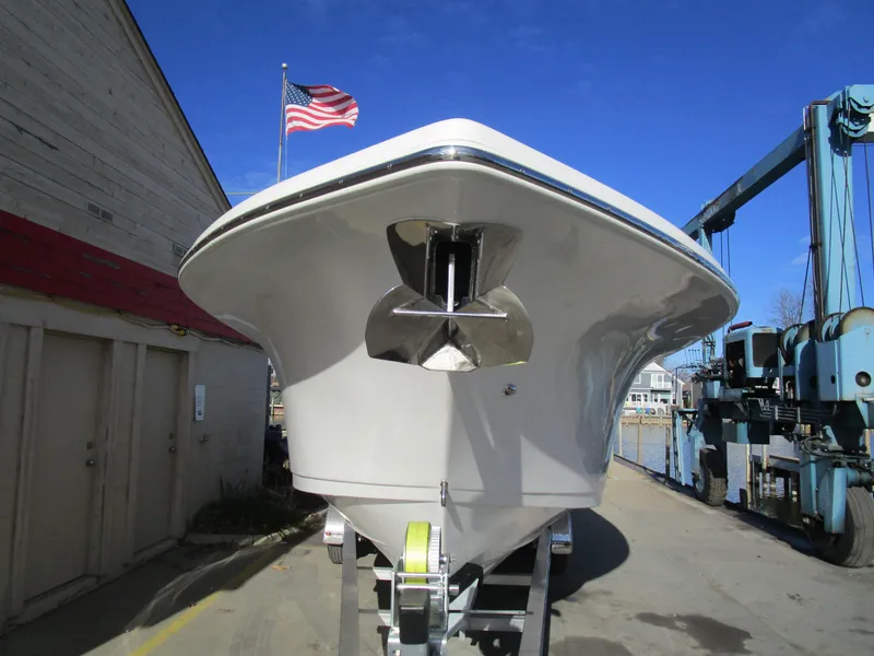 Slide: The Image of 2024 Sea Pro 322 Offshore boat on trailer, front view, with American flag in background. - 3