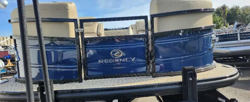 Slide: The Image of 2024 Regency 250 LE3 Sport pontoon boat, rear view, blue and beige upholstery. - 1