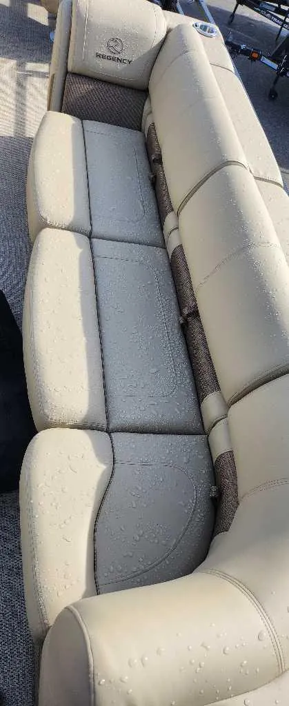 Slide: The Image of 2024 Regency 250 LE3 Sport boat with beige leather seating, water droplets visible. - 12