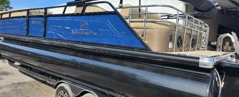 Slide: The Image of 2024 Regency 250 LE3 Sport pontoon boat on a trailer. - 2