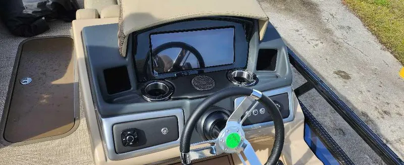 Slide: The Image of 2024 Regency 250 LE3 Sport boat dashboard with steering wheel and touchscreen display. - 7