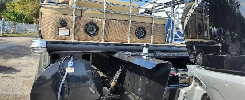 Slide: The Image of 2024 Regency 250 LE3 Sport pontoon boat rear view with motor and seating. - 8