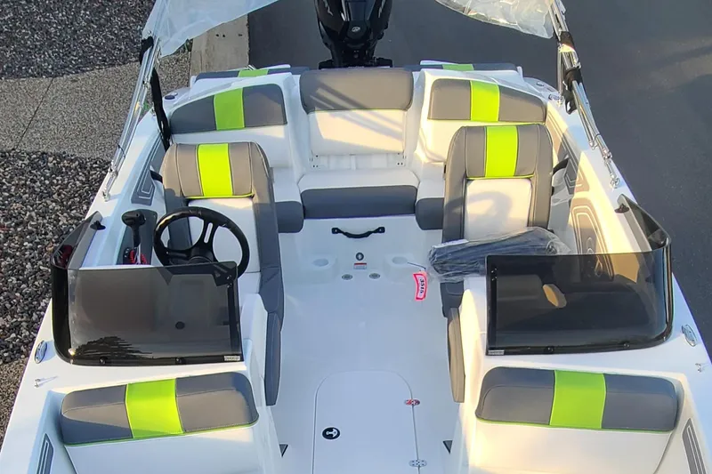 Slide: The Image of 2024 Tahoe T21 boat interior with gray and green seating, steering wheel, and windshield. - 5