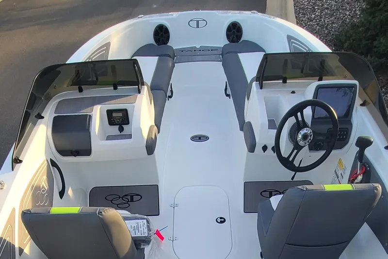 Slide: The Image of 2024 Tahoe T21 boat interior with dual consoles, steering wheel, and seating. - 6