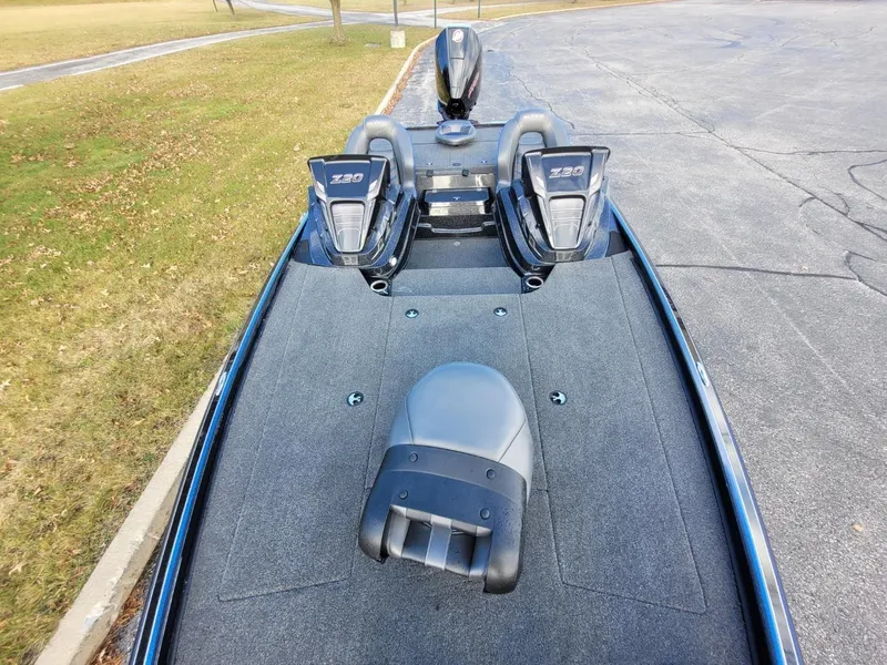 Slide: The Image of 2024 Nitro Z20 Pro fishing boat with dual outboard motors on a paved surface. - 4