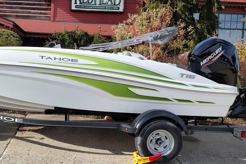 Slide: The Image of 2024 Tahoe T16 boat with green accents on a trailer, featuring a Mercury engine. - 1