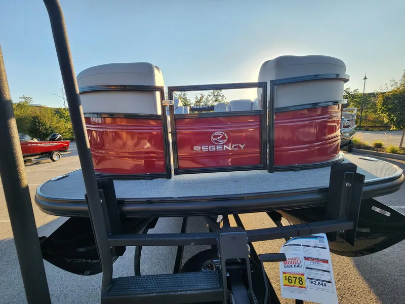 Slide: The Image of 2024 Regency 250 DL3 pontoon boat, red exterior, displayed outdoors. - 2