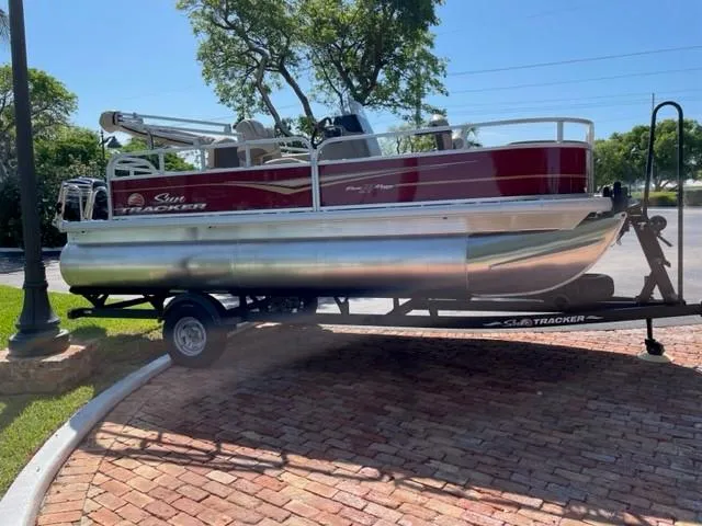 Slide: The Image of 2024 Sun Tracker Bass Buggy 18 DLX pontoon boat on a trailer. - 2