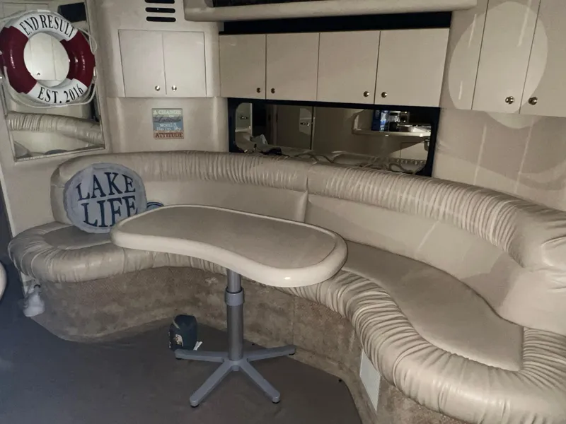 Slide: The Image of 1999 Sea Ray 380 Sundancer interior with curved seating and table. - 11
