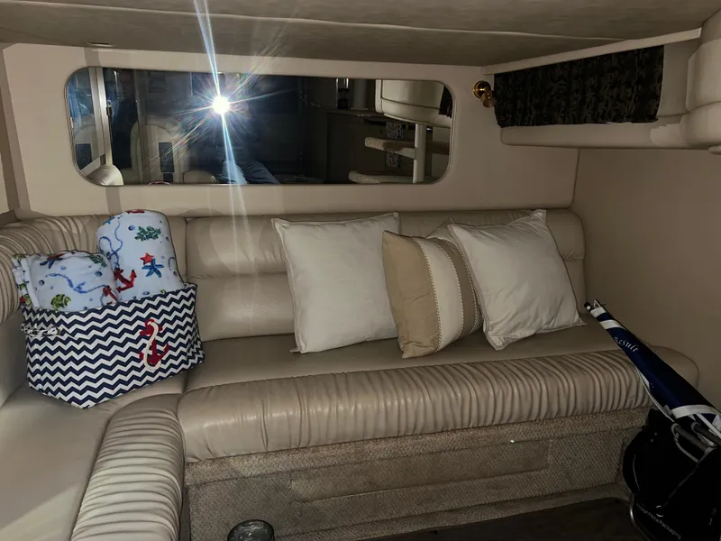 Slide: The Image of Interior of 1999 Sea Ray 380 Sundancer with beige leather seating and decorative pillows. - 13