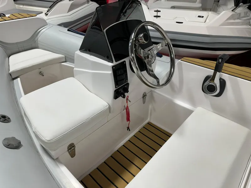 Slide: The Image of 2024 Tiger Marine PT 340 boat interior with steering wheel and cushioned seating. - 4
