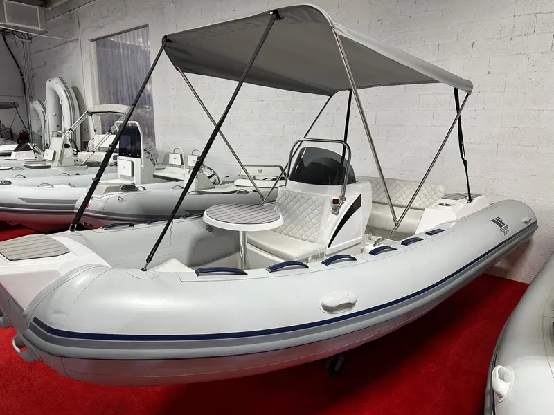 The Image of 2024 Tiger Marine SL 480 inflatable boat with canopy and seating, displayed indoors. - 0