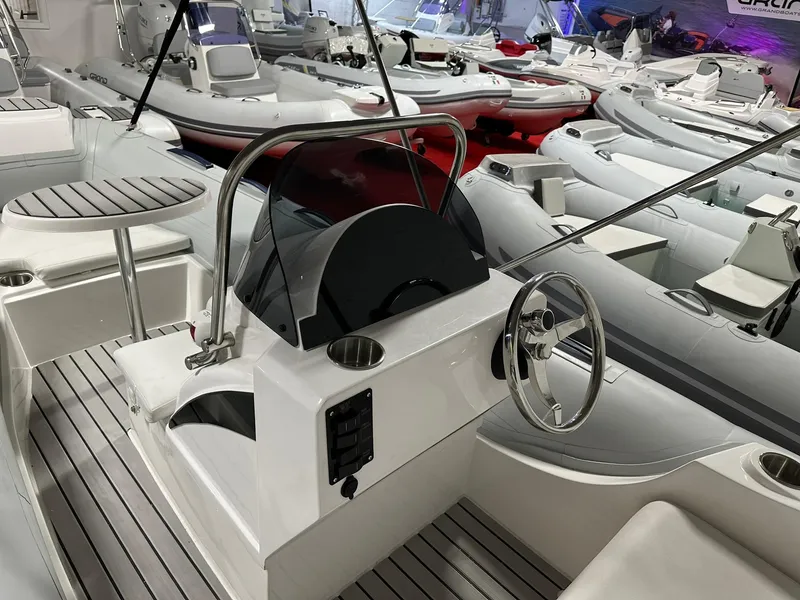 Slide: The Image of 2024 Tiger Marine SL 480 boat interior with steering wheel and seating. - 2