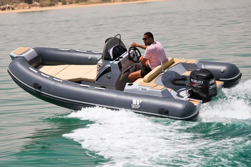 Slide: The Image of 2024 Tiger Marine SL 480 inflatable boat cruising on water with Suzuki outboard motor. - 22