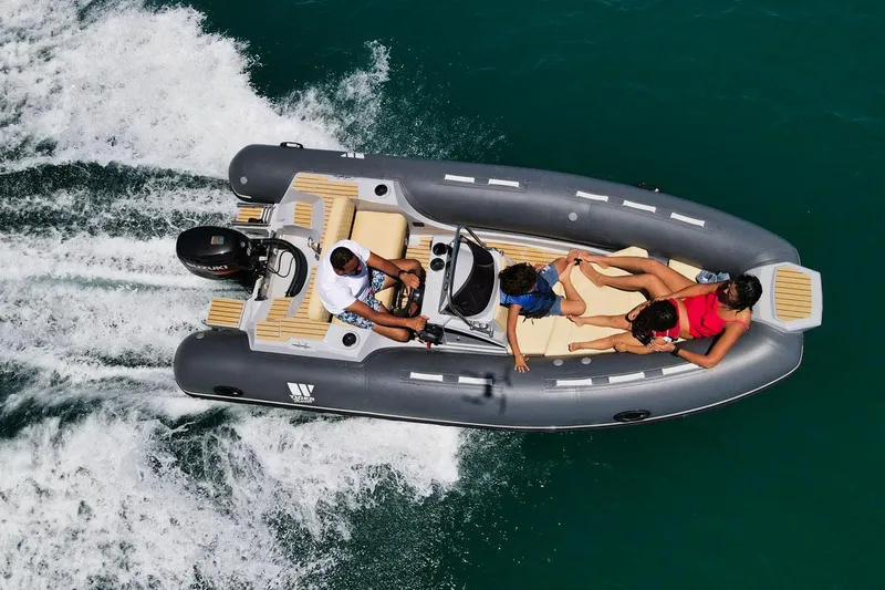 Slide: The Image of 2024 Tiger Marine SL 480 boat cruising with passengers on turquoise water. - 5