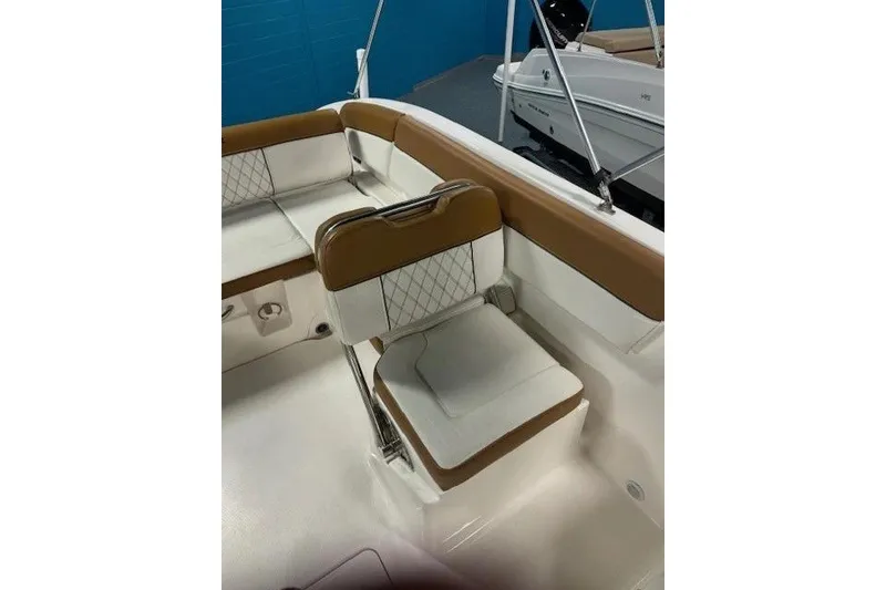 Slide: The Image of 2021 Bayliner DX 2200 boat interior with tan and white seating. - 10