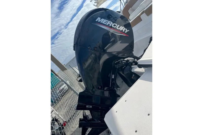 Slide: The Image of Mercury outboard motor on 2021 Bayliner DX 2200 boat, docked with blue sky background. - 14