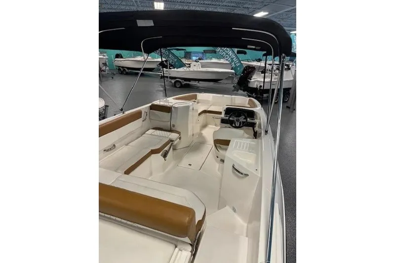 Slide: The Image of 2021 Bayliner DX 2200 boat interior with seating and steering wheel, displayed indoors. - 8