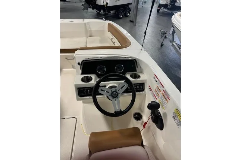 Slide: The Image of 2021 Bayliner DX 2200 boat cockpit with steering wheel and control panel. - 9