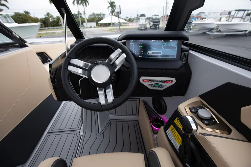 Slide: The Image of 2024 Nautique Super Air Nautique S23 boat cockpit with modern steering wheel and touchscreen display. - 12