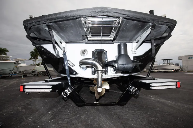 Slide: The Image of 2024 Nautique Super Air Nautique S23 boat stern view with propeller and exhaust system. - 16