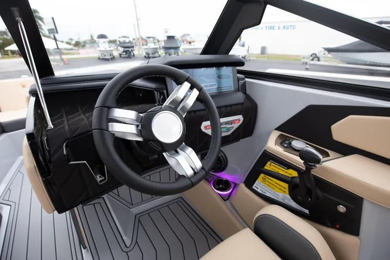 Slide: The Image of 2024 Nautique Super Air Nautique S23 boat cockpit with modern steering wheel and control panel. - 3