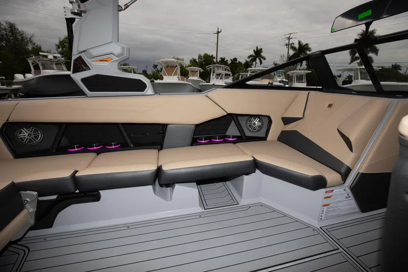 Slide: The Image of 2024 Nautique Super Air Nautique S23 interior with beige and black seating, purple LED lights. - 4