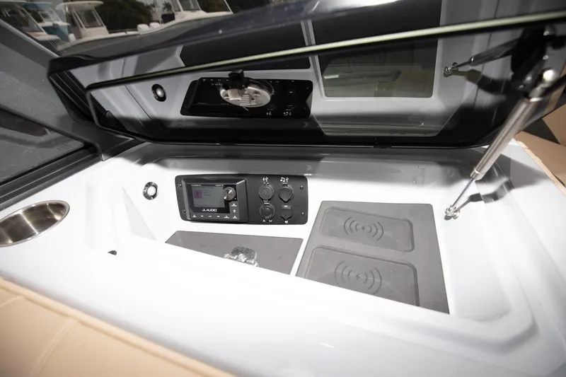 Slide: The Image of 2024 Nautique Super Air Nautique S23 storage compartment with control panel and wireless charging pads. - 7