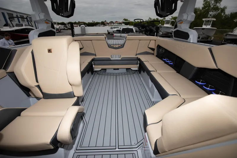 Slide: The Image of 2024 Nautique Super Air Nautique S23 interior with beige seating and gray flooring. - 8
