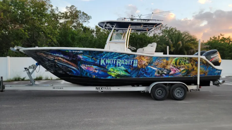 The Image of 2010 Sea Fox 286 Commander boat with vibrant marine-themed graphics on a trailer. - 1
